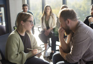 Support group discussing workplace psychosocial safety during organisational change.