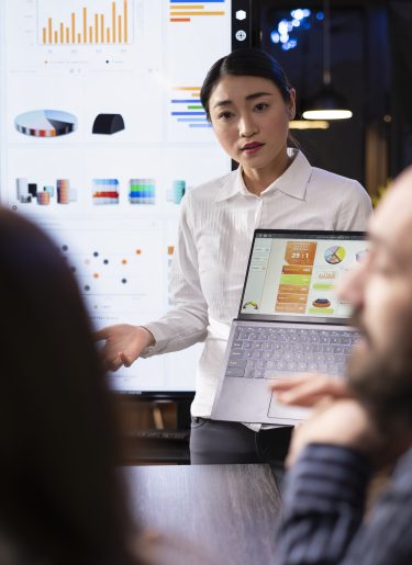 Woman presenting charts and data on a board during a meeting, Korean performance bonuses