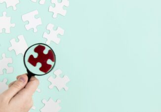 Magnifying glass highlighting a red puzzle piece
