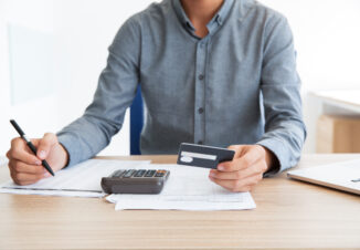 Man writing credit card number at desk
