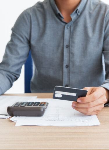 Man writing credit card number at desk