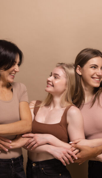 Women from diverse backgrounds hugging.