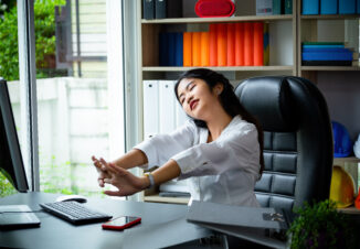 Yong woman stretching at work