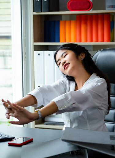 Yong woman stretching at work