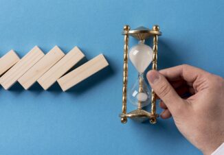 Domino pieces with a businessman holding hourglass