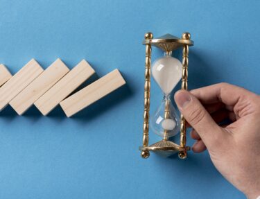 Domino pieces with a businessman holding hourglass