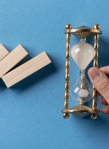 Domino pieces with a businessman holding hourglass