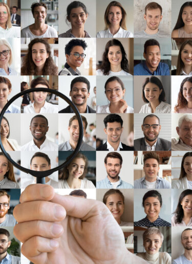 Hr holding magnifying glass choosing african candidate among people faces