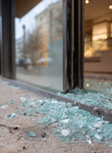Broken storefront window with glass fragment on sidewalk. aftermath of crime and damage creating scene of urban destruction and chaos